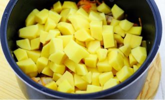 Pendant que la viande et les légumes sont frits, épluchez les pommes de terre, lavez-les et coupez-les en barres ou en cubes de taille moyenne, puis ajoutez-les dans le bol du multicuiseur.