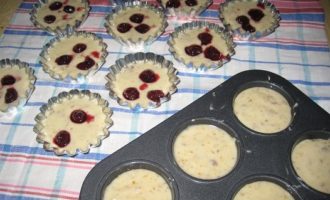 Smør formene med olie, og du kan bage cupcakes i både silikone- og metalforme. Dernæst kan dejen deles i to dele, hvoraf den ene tilsættes en skefuld appelsinskal. Fordel dejen i formene, fyld dem to tredjedele op. Læg kirsebær i dejen uden skal og hæld en lille mængde dej oven på bærrene.