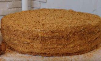 Cubra todos los pasteles con crema agria, asegurándose de engrasar los lados. Apílalos uno encima del otro y espolvoréalos con la masa rallada. Coloque el pastel en el refrigerador durante 8 a 10 horas hasta que esté completamente empapado. Decora el clásico pastel de miel terminado a tu gusto.