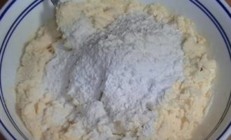 Aggiungere la farina setacciata con il lievito, mescolare l'impasto. Lasciare agire per 30 minuti in modo che gli ingredienti diventino amici tra loro e si ottengano soffici cheesecake in padella.