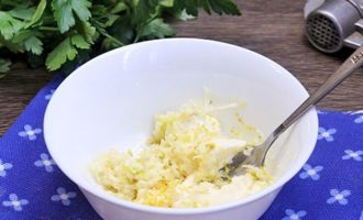 Saca la mantequilla del frigorífico para que se derrita un poco. Mientras tanto, pase los dientes de ajo por una prensa de ajos y agréguelos a la mantequilla blanda. Agregue allí la ralladura de limón y amase bien este aderezo de aceite.