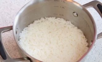 Cocine el arroz de grano grueso lavado y sin sancochar en una cacerola aparte durante 2 minutos y luego déjelo durante 15 minutos para que absorba el líquido. Luego escurre el agua restante.