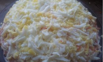 Por último, pero no menos importante, la ensalada se complementa con huevos y remolacha. Primero, ralla los huevos y colócalos con cuidado sobre la superficie de la ensalada.