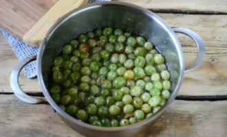 In the morning, place the bowl with gooseberries on low heat and cook for 5 minutes from the start of the boil. Turn off the heat and leave the jam for 6–8 hours. We repeat this process of five-minute cooking with a break 3-5 times, that is, in the morning and in the evening.