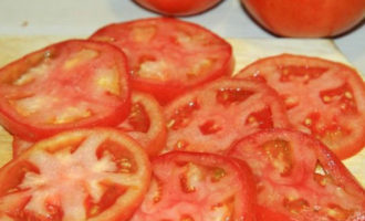 Tagliare i pomodori rimanenti negli stessi cerchi delle melanzane. Utilizzare un coltello molto affilato, altrimenti il ​​centro dei pomodori maturi potrebbe cadere, ma ciò non dovrebbe essere consentito.