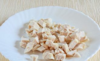 L'insalata di pollo e ananas è facile e veloce da preparare. Lavare il petto di pollo, eliminare la pelle e le ossa. Al posto del petto potete usare il filetto di coscia, la carne di questa parte del pollo è più succosa. Puoi anche usare il pollo affumicato, quindi il gusto sarà ricco e luminoso. Lessare il filetto in acqua salata finché sarà tenero. Lasciarlo raffreddare, quindi tagliarlo a cubetti.