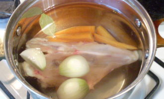 Peel the garlic cloves and onions. Peel the carrots in a thin layer. Rinse all vegetables under running water. When the water starts to boil, carefully skim off the foam and salt the broth. Add the whole vegetables, and also throw peppercorns and two bay leaves into the pan. Reduce heat to medium and cook chicken until tender.