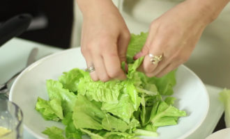 Az edény alját beborítjuk tépett salátalevelekkel, rátesszük a csirkét és a sajtot.