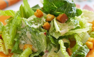 Polvilhe com o pão ralado já resfriado, regue com o molho de alho. Coloque os tomates picados por cima. Você pode polvilhar com parmesão ralado. A salada César com frango em casa segundo a receita clássica está pronta!