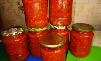 Pour boiling adjika into prepared jars and cover with lids. Take a very large saucepan, place jars with vegetable preparations in it, pour water into the saucepan so that it almost completely covers the jars (there should be 1-2 fingers left to the top of the jar). Bring the water to a boil and let the jars of adjika simmer for about 15 minutes, then carefully remove the hot jars and immediately seal them with lids. Turn the pieces upside down and cover with a warm blanket. After cooling completely, move the jars to a place where it will be constantly dark and cool.