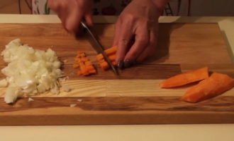 Puliamo le verdure. Tagliare la cipolla e le carote a listarelle sottili. Tagliare gli spicchi d'aglio a fettine. Tagliamo le patate a quadretti e le mettiamo in un piatto con acqua. Lavare il cavolo e tagliare la testa fino al gambo.