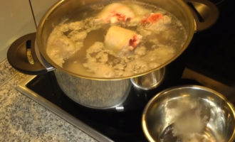 Écumez constamment toute mousse qui apparaît à la surface afin que le bouillon soit clair. Vous pouvez égoutter le bouillon bouilli, rincer la viande, ajouter de l'eau froide et poursuivre la cuisson. Cuire la viande en gelée à feu doux couvercle fermé pendant 5 heures.