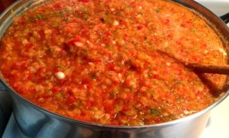 Pour the resulting vegetable mass into a fairly spacious saucepan, add sugar, salt, sunflower oil, vinegar and place over medium heat. After the adjika boils, reduce the heat and simmer for about 20 minutes. While the adjika is cooking, wash the jars in hot water with a small amount of baking soda added. 