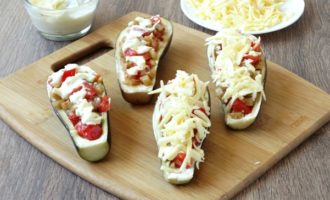 Grease each eggplant boat with a mixture of mayonnaise and garlic. Fill the boats with filling and sprinkle with cheese.