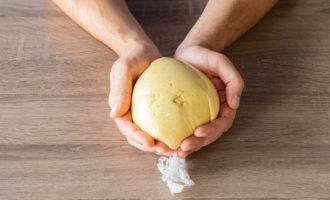 Form the resulting dough into a ball and wrap it in cling film. If the dough sticks to your hands, add a little more flour. Place the dough in the refrigerator for half an hour so that it matures and is easier to roll out.