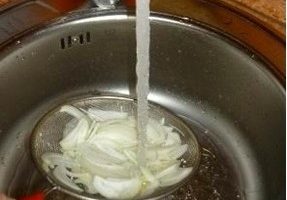 Place the onion in a sieve or colander and rinse thoroughly under cold running water to remove the bitterness.