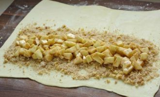 Place the puff pastry, defrosted in advance, on baking paper or a cutting board and roll out much. Sprinkle the dough sheets evenly with a mixture of nuts and breadcrumbs. Place the prepared apple filling on top.