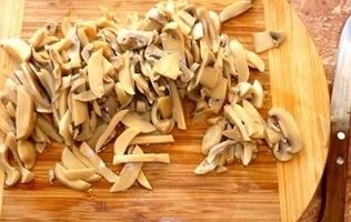 Open the jar of mushrooms, pour 2 tsp directly into the marinade.vinegar 9% and let stand for 20 minutes, then place the mushrooms in a sieve, let the moisture escape, cut the mushrooms into strips.