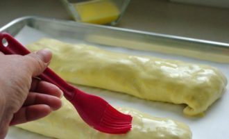 Line a baking tray with paper and grease it a little with vegetable oil. Place the rolls on a baking sheet, seam side down. Mix one yolk with a teaspoon of water and spread the mixture onto the rolls.