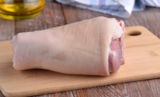 Comment cuire délicieusement un jarret de porc en papillote au four ? Choisissez une articulation belle et solide avec une peau propre et sans dommage. Lavez-le à l'eau froide, grattez la peau avec un couteau et rincez bien à nouveau. Séchez la jambe avec du papier absorbant.