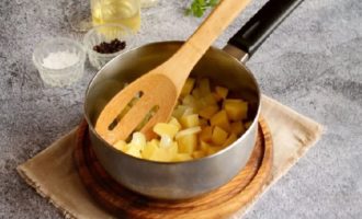 Place a thick-bottomed saucepan on the stove, add vegetable or olive oil and start heating. At this time, chop the onion into smaller pieces and cut the potato tubers into cubes or cubes. First, put the onion in the saucepan, and after a minute - the potatoes. Then add the garlic, previously crushed using a garlic press. Mix the ingredients and fry for about a minute over low heat.