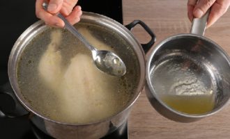 Reduza o fogo e cozinhe o frango por cerca de 40 minutos, retirando ocasionalmente a gordura da superfície do caldo e despejando-o separadamente em uma panela pequena.