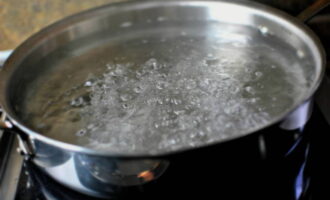 Per preparare l'insalata di calamari, innanzitutto mettete l'acqua in un pentolino sul fuoco. Abbiamo bisogno che bolle. 