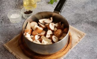 Basuh champignons, kupas dan potong menjadi empat. Letakkan cendawan cincang dalam periuk dan masak semuanya bersama selama beberapa minit lagi, jangan lupa kacau dahulu.