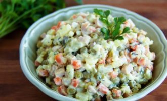 Escurre el líquido de los guisantes y colócalos en un bol grande. Agregue allí las papas picadas, las zanahorias, los huevos, los pepinos y las salchichas, sazone con mayonesa y mezcle. Pruebe la ensalada para ver si tiene sal y agregue sal si es necesario. El clásico Olivier está listo, decóralo con hierbas frescas y sirve.