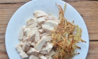 Lessare il petto di pollo e le uova in contenitori separati fino a cottura. Fai bollire le uova sode. Tagliare il petto bollito a listarelle sottili (per rendere la carne più saporita e succosa aggiungere spezie e sale al brodo, quindi raffreddarla senza toglierla dal brodo). Friggere le patate nell'olio finché sono tenere, eliminare l'olio in eccesso mettendo le patate su un tovagliolo di carta.