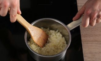 Cortar la cebolla pelada en trozos pequeños. Coloca a fuego medio el cazo en el que se vertió la grasa del caldo y calienta el contenido. Agrega la cebolla, reduce el fuego al mínimo y cocina a fuego lento la cebolla hasta que esté blanda, sin dejar que se fría hasta que se dore. Cocine por 10 minutos. y retirar del fuego.