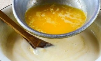 Melt the butter in a small saucepan or microwave. Wait until the oil has cooled, and then gradually introduce it into the dough.