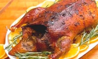 Place the cooked soft and juicy turkey on a beautiful dish and decorate with orange slices and fresh herbs.