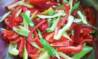 We wash the peppers, cut them in half, cut out the stalks, remove seeds and membranes, and cut the flesh into small strips.Place the chopped peppers in a saucepan with the tomato mixture and simmer the vegetables over medium heat.