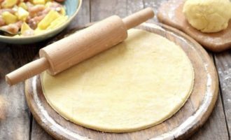 Grease the baking dish with oil. Divide the dough into two unequal parts 1 to 3. Roll out most of it and place it on the bottom of the mold, making high sides.