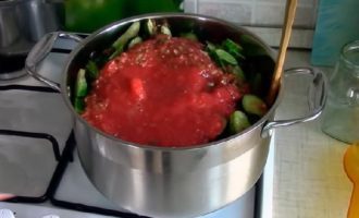 Grind all chopped vegetables except cucumbers in a meat grinder with a medium grid. Place chopped cucumbers in a special stewing pan and pour in the prepared vegetable sauce of tomatoes and peppers.