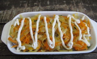 Place the remaining half of the onion and carrots on the fish fillet. Then carefully cover the top with mayonnaise or sour cream.