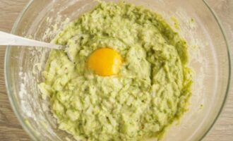 Add the chopped onion to the zucchini dough. Break the eggs here and mix everything thoroughly until smooth.