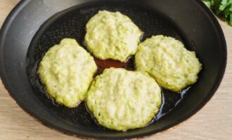 Heat a frying pan with vegetable oil. Place the dough for zucchini pancakes here. Fry until golden brown on each side. This will take approximately 7-10 minutes.