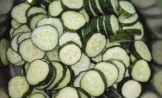 How to prepare a delicious cucumber and onion salad for the winter? Wash the vegetables well under cold water. Cut them into circles 0.5 centimeters thick and place them in a deep bowl.