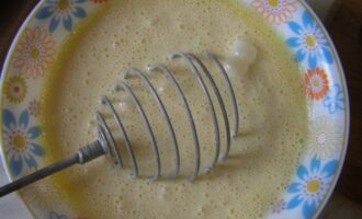 In a separate bowl, beat eggs and sour cream. Grate the cheese on a coarse grater.