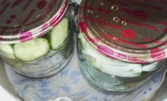 Place the cucumber and onion salad tightly into the jars and cover them with lids. Place a towel folded several times at the bottom of the pan, then place the jars in it and fill them with water. Sterilize jars of salad in boiling water for 20 minutes.