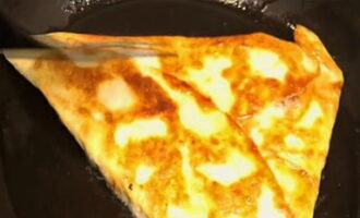 Scaldare bene la padella a fuoco basso. Versare una piccola quantità di olio d'oliva. Disporre la pita piegata a triangolo. Posizionarlo piegato verso il basso e friggerlo fino a doratura su entrambi i lati.