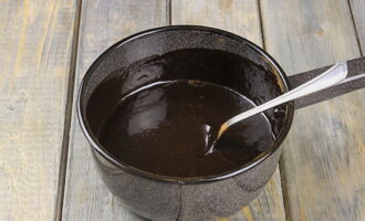 Pour the specified amount of cream and water into the dry mixture of sugar and cocoa. Place the saucepan on the stove and stir the contents. Bring the glaze to a boil, stirring vigorously - the mass should become completely homogeneous. Immediately after boiling, remove the saucepan from the stove and add chocolate, broken into small pieces and pour in cognac. Stir until smooth. 