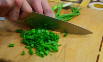 We wash the green onion feathers and dry them with a napkin. Then finely chop it and sprinkle it on the liver layer.