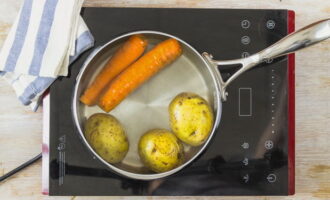 To prepare the classic Olivier salad with sausage, boil vegetables - carrots and potatoes.