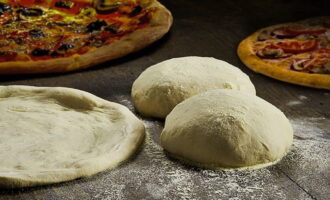 Lăsați aluatul rezultat timp de 10-15 minute, apoi stropiți cu făină și rulați într-un strat subțire. Aluatul de pizza cu kefir fără drojdie este gata!