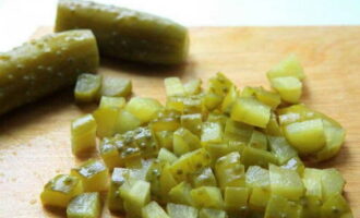 Peel the cucumbers and chop them into small cubes, then place them in the next layer.