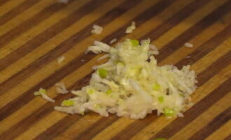 Using a fine grater, chop the pre-peeled garlic.