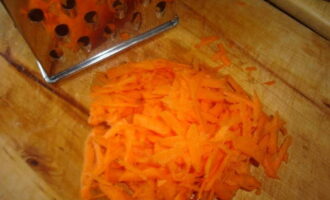 We clean the boiled carrots and also chop them on a coarse grater and place them in the next layer on top of the eggs.